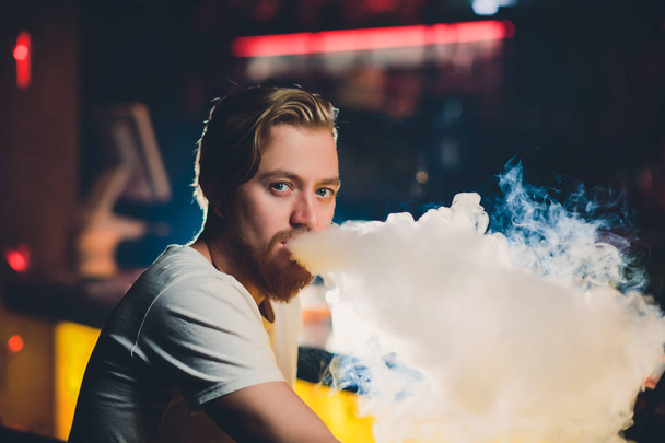 Young Man Smoking Shisha At Arabic Restaurant - Man Exhaling Smoke Inhaling From A Hookah. - Foto, afbeelding