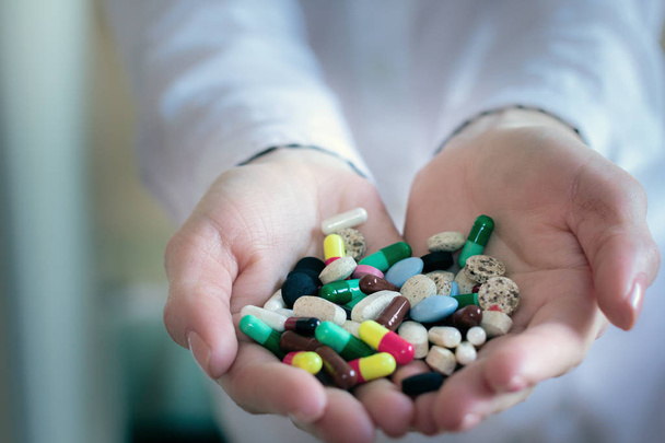 pilules différentes et colorées capsules dans les mains d'un médecin
 - Photo, image
