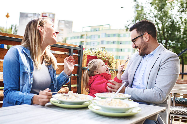 Happy family is enjoying pasta in restaurant. - Foto, Bild