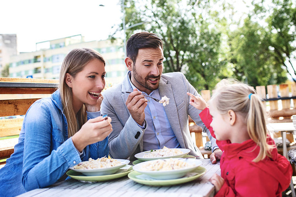 Happy family is enjoying pasta in restaurant. - Photo, Image