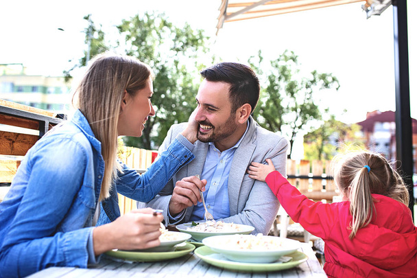 Happy family is enjoying pasta in restaurant. - Foto, imagen