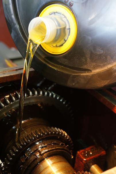 Un mecánico vierte aceite fresco en un coche
 - Foto, Imagen