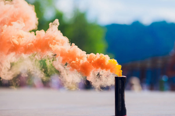 colorful orenge smoke bombs in action - Фото, изображение