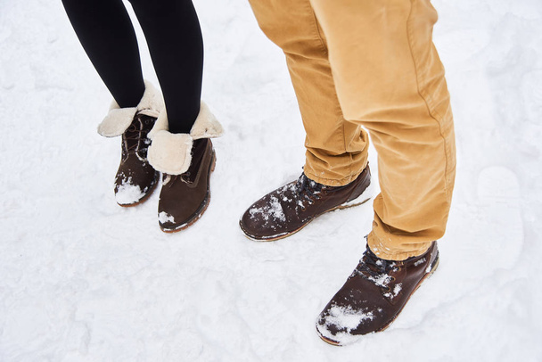coppia innamorata indossare stivali marroni soggiorno sulla neve fresca bianca
 - Foto, immagini