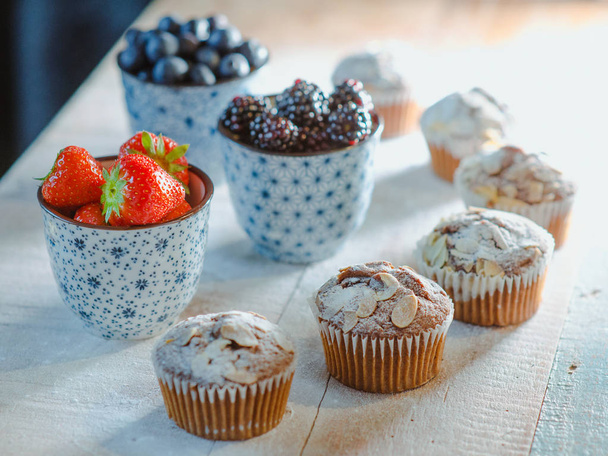 strawberry, blackberry, blueberry and muffins on the table - Фото, зображення