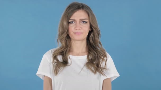 Verdrietig, boos meisje geïsoleerd op blauwe achtergrond - Video