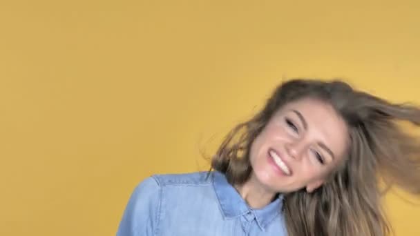 Gelukkig Young Girl schudt haar hoofd geïsoleerd op gele achtergrond - Video