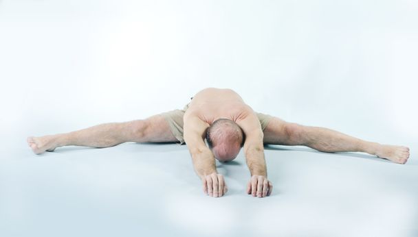 Portrait of strong man sitting in yoga pose - Foto, afbeelding
