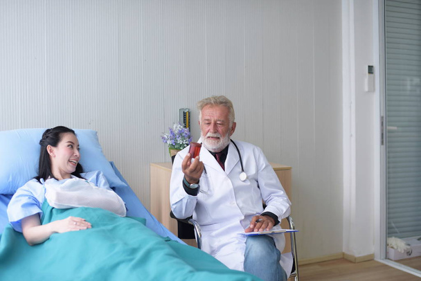 The doctor takes care and encourages the patient at the hospital.cheerful  doctor talking with young woman patient for monitoring and check up after surgery. - Фото, зображення
