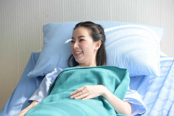 Aisan woman lying on bed in hospital - Valokuva, kuva