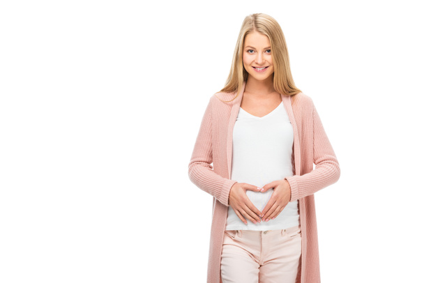 улыбающаяся беременная женщина показывает знак сердца с руками, изолированными на белом
 - Фото, изображение