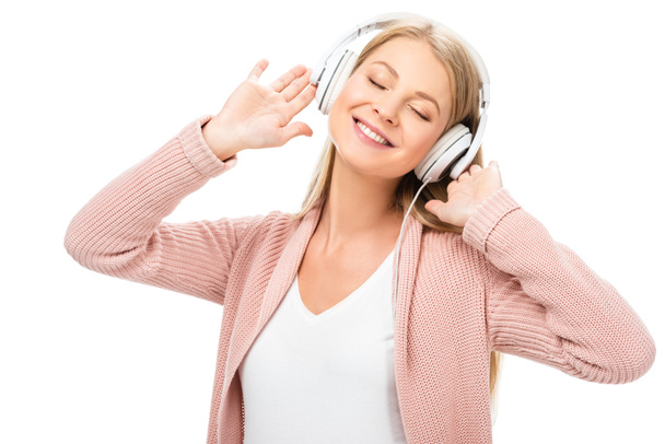 woman enjoying music, using headphones and smiling with closed eyes isolated on white - Foto, imagen