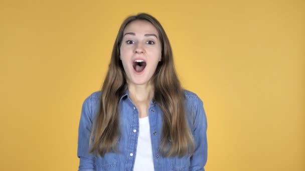 Pretty Woman Gesturing Silence, Finger on Lips, Yellow Background - Video