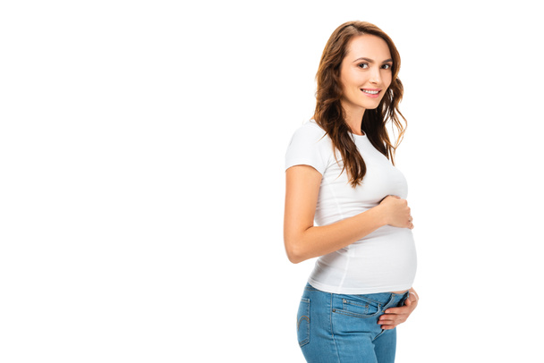 beautiful smiling pregnant woman touching belly with both hands isolated on white - Foto, Imagem