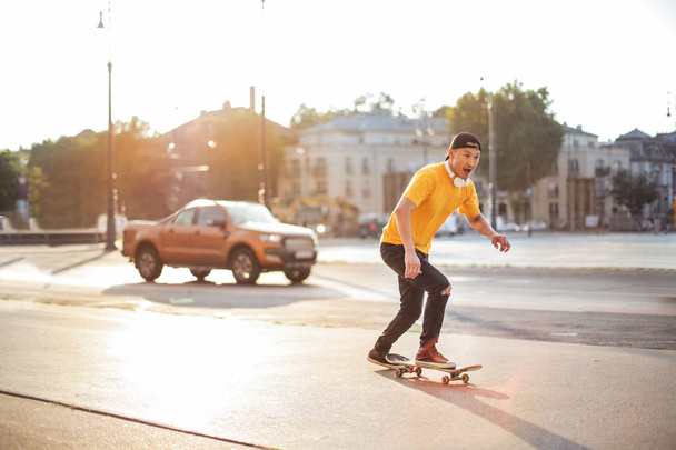 young asian man skateboarding in the street - Valokuva, kuva