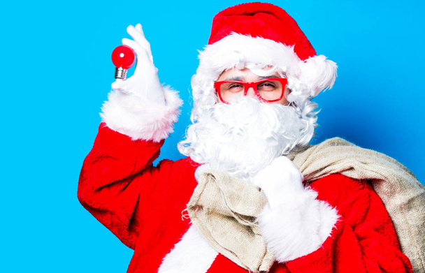 Funny Santa Claus have a fun with light bulb - Φωτογραφία, εικόνα