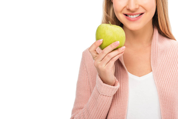oříznutý pohled krásná žena s úsměvem a drží jablko izolované na bílém - Fotografie, Obrázek