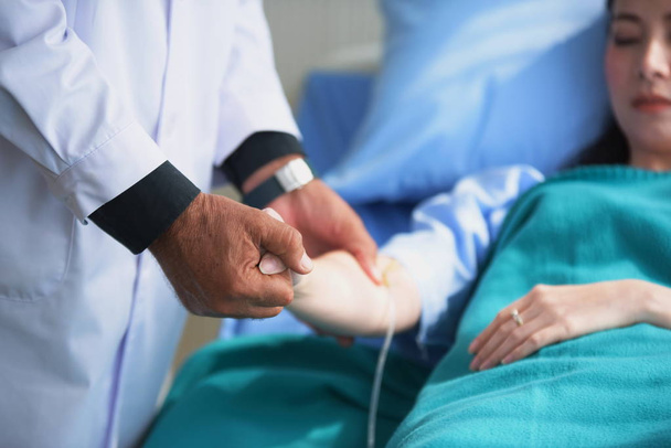 El doctor sostiene la mano del paciente en la habitación del hospital
 - Foto, Imagen