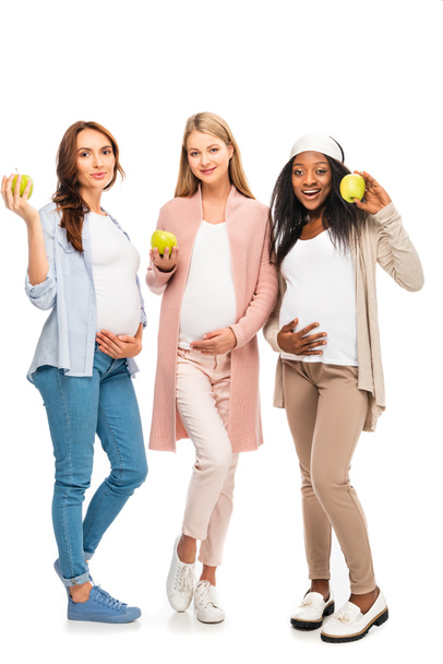 tutta la lunghezza delle donne incinte in piedi e tenendo frutta in mano isolata su bianco
 - Foto, immagini