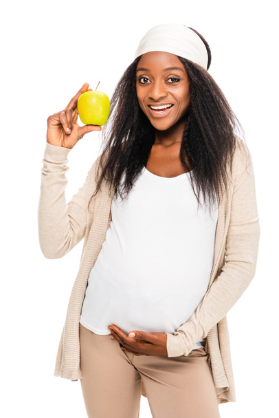 africano americano feliz embarazada mujer celebración manzana en mano aislado en blanco
 - Foto, Imagen