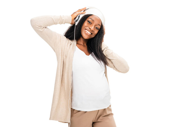Африканский американец улыбается беременная женщина слушает музыку изолированы на белом
 - Фото, изображение