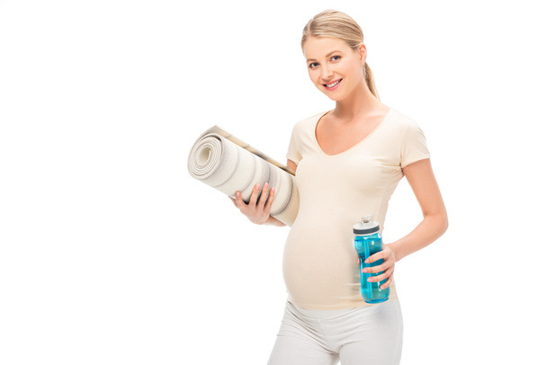 terhes szőke nő, fitness szőnyeg és elszigetelt fehér üveg - Fotó, kép