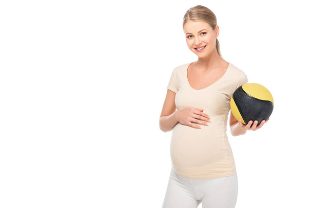 Happy těhotná blondýna žena držení míče v levé ruce izolované na bílém - Fotografie, Obrázek