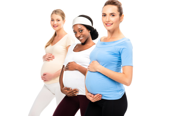 three pregnant women holding hands on bellies and smiling isolated on white - Foto, Imagem