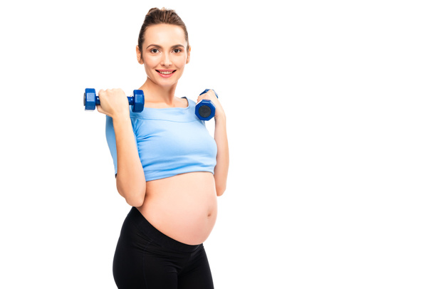pregnant woman holding dumbbells near shoulders isolated on white - Photo, Image