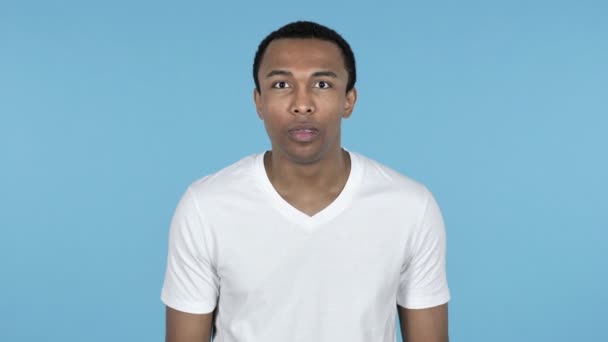 Shocked Surprised Young African Man Standing Isolated on Blue Background in Wonder - Footage, Video