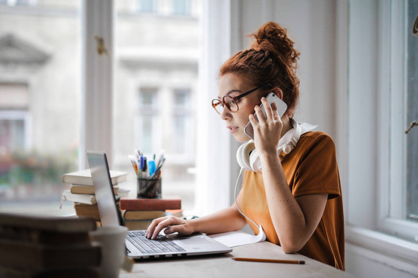 woman on the phone while working and studying - Valokuva, kuva