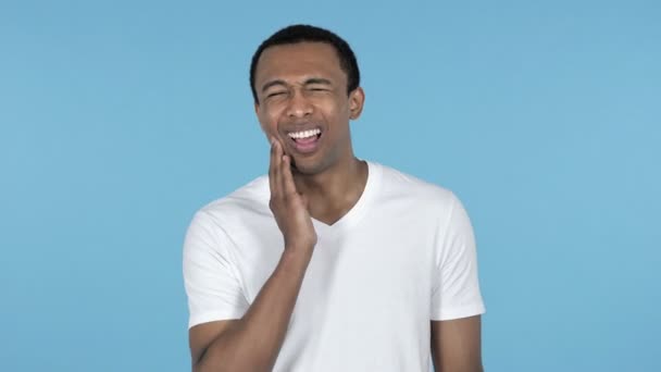 Bolesti zubů, africký mladík s bolestí zubu izolované na modrém pozadí - Záběry, video