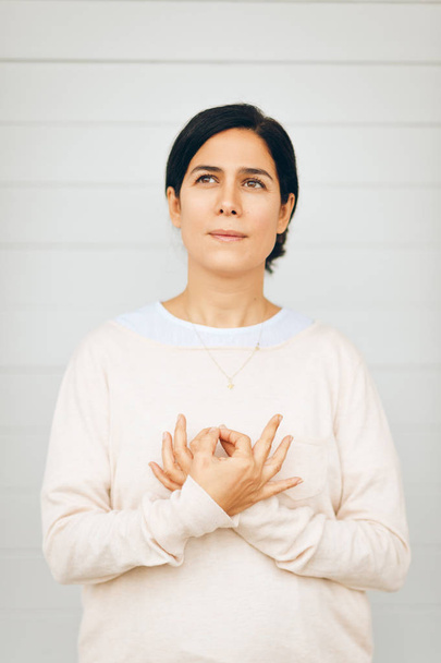 Portrait of woman holding gyan mudra next to heart, hand position from Kundalini yoga meditation Love is Love. This meditation removes any duality between love in your life and love in your soul - Photo, Image