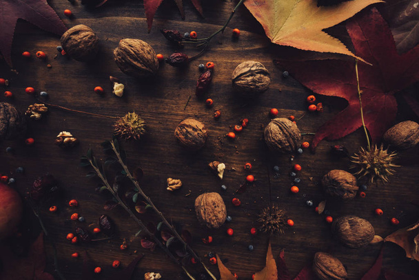 Rustic top view flat lay autumn arrangement decoration with some fruit and dry maple leaves on wooden table - Fotoğraf, Görsel