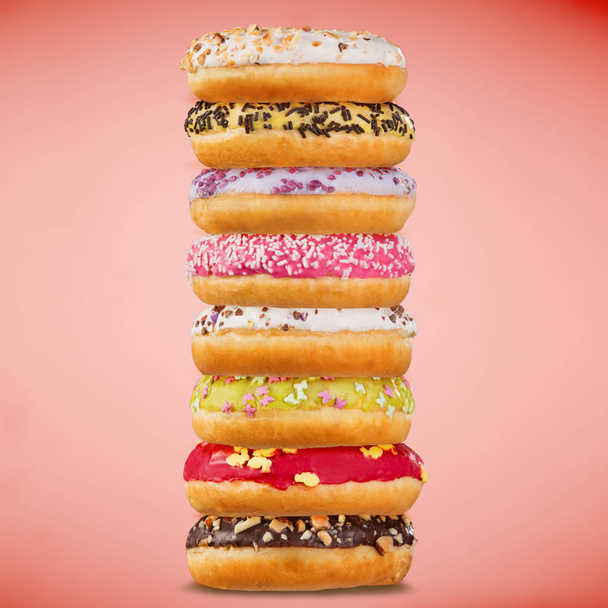 Stack of assorted donuts on pastel background. - Фото, зображення