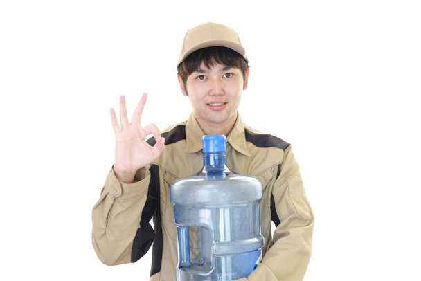 Trabajador con un recipiente de agua
 - Foto, Imagen