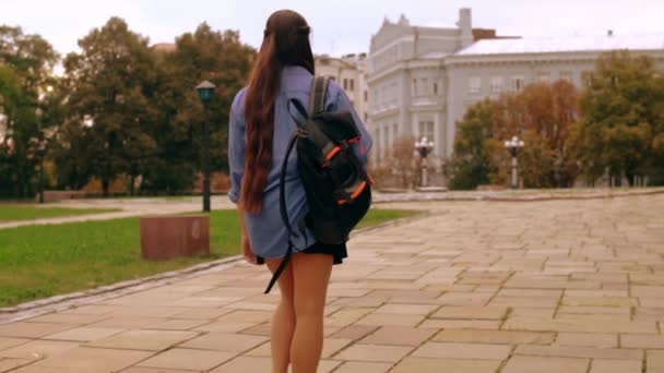 pohled zezadu mladá žena chůzi s batohem v městě - Záběry, video
