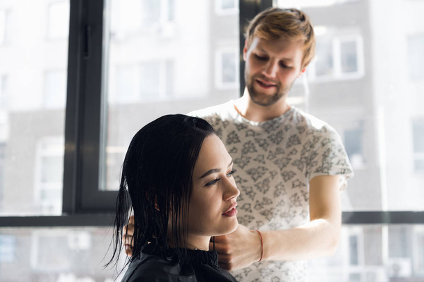 Улыбающаяся женщина стрижется у красивого парикмахера
 - Фото, изображение