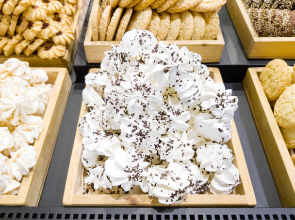 Deliciosos merengues dulces con nueces y chocolate y galletas en el escaparate
 - Foto, imagen
