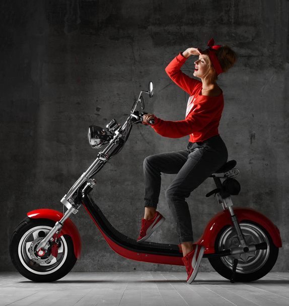 Woman ride sit on motorcycle bicycle scooter pinup retro style laughing smiling looking at the corner - Zdjęcie, obraz