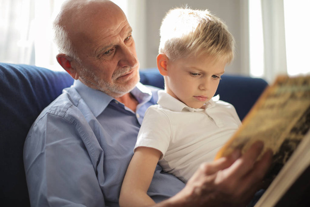 grandfather reading book for his grandson - Фото, зображення