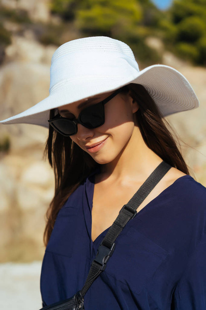 Молода струнка жінка з великим білим капелюхом влітку
 - Фото, зображення