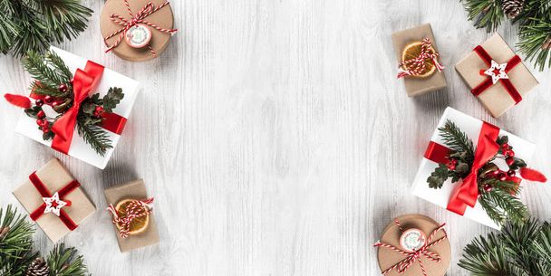Weihnachtsgeschenkschachteln auf weißem Holzgrund mit Tannenzweigen, Tannenzapfen. Weihnachten und ein gutes neues Jahr Thema. flache Lage, Draufsicht, Platz für Text - Foto, Bild