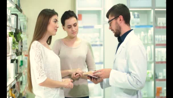 Il giovane farmacista mostra a due clienti della farmacia la disponibilità di farmaci di loro interesse.
 - Filmati, video