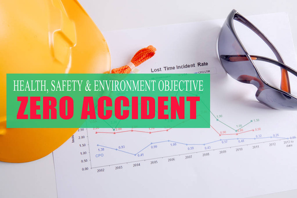 Gesundheits-, Sicherheits- & Umweltziel: Null Unfälle mit gelbem Schutzhelm, Sicherheitsglas und Ohrstöpsel über Unfallstatistik. - Foto, Bild