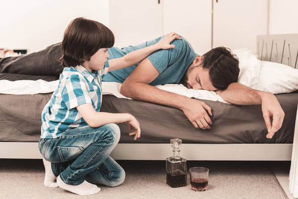 Little Boy Sitting in Room with Drunken Father. Crisis in Family. Alcoholism Problem Concept. Glass of Whiskey. Young Boy in Shirt. Modern Social Problems Concept. Sitting Sad Boy. - Foto, Bild