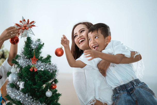 Μητέρα και γιος στολίζουν χριστουγεννιάτικο δέντρο - Φωτογραφία, εικόνα