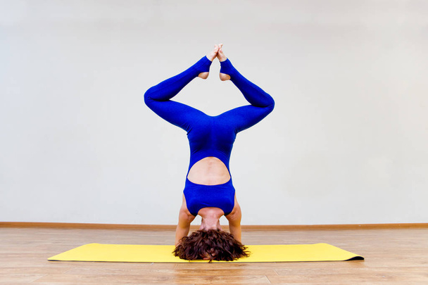 a woman practicing yoga exercises at home - Fotó, kép