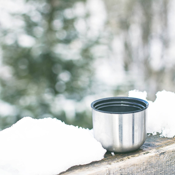 Cup of Thermos on the background of the winter landscape.  - Foto, imagen