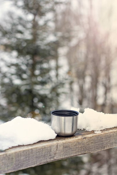 Cup of Thermos on the background of the winter landscape.  - Fotoğraf, Görsel